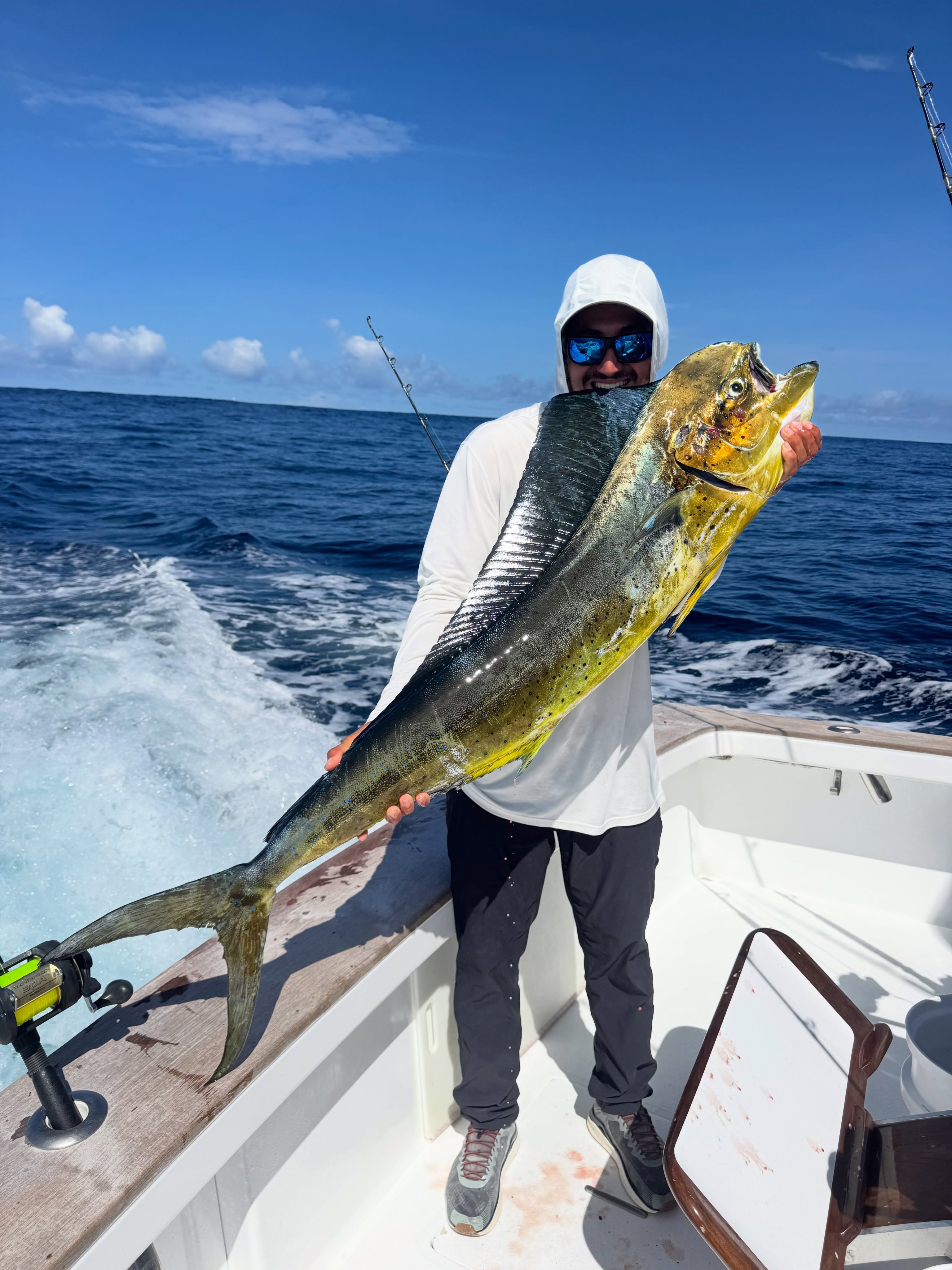 Angler holding a mahi-mahi aboard Tiger Fly